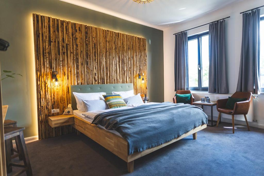 a bedroom with a large bed with a wooden wall at Boutique Hotel LANDHAUSZEIT in Bad Münstereifel