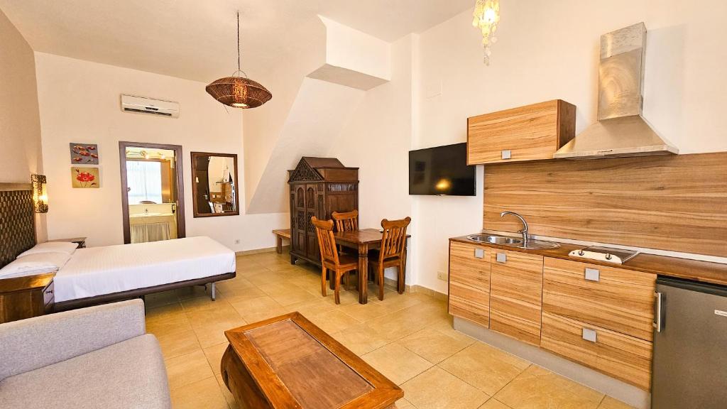 a room with a bed and a kitchen with a table at Zahara Sol Villas y Apartamentos by QHotels in Zahara de los Atunes