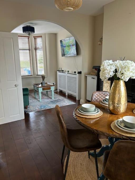 a dining room with a table and a vase of flowers at Railwayview Lodge in Bangor