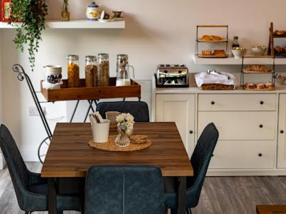 a kitchen with a wooden table with chairs and a counter at Carrick Gate in Carrick