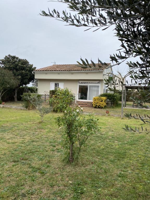 a small house in a yard with a tree at Casa Les Roques in Báscara