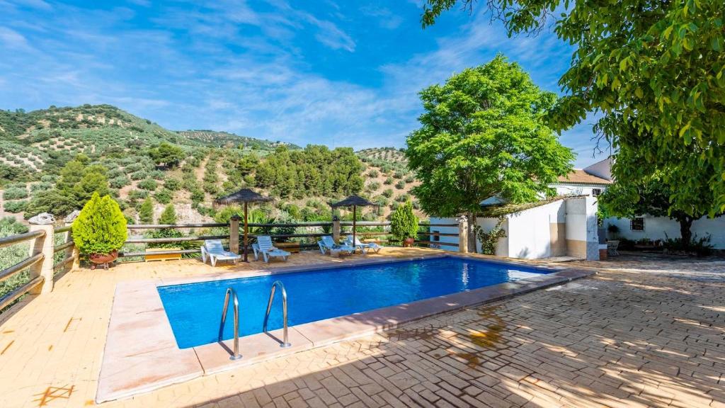 une maison avec piscine avec une montagne en arrière-plan dans l'établissement Las Nogueras de Montefrío by Ruralidays, à Montefrío
