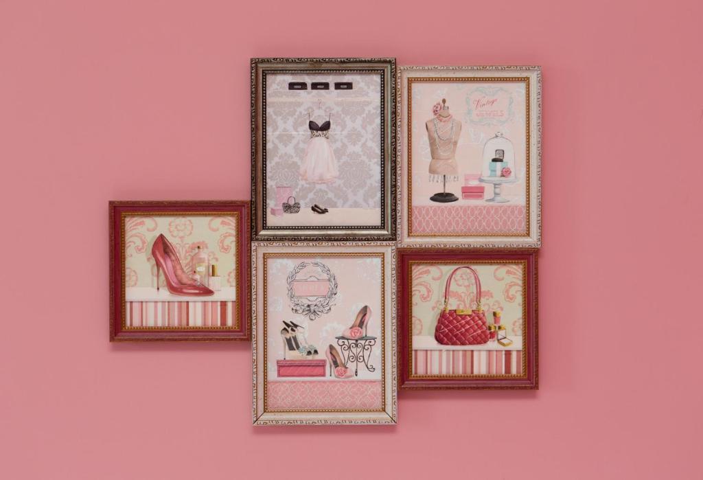a group of framed pictures on a pink wall at Wei Sen House in Hualien City