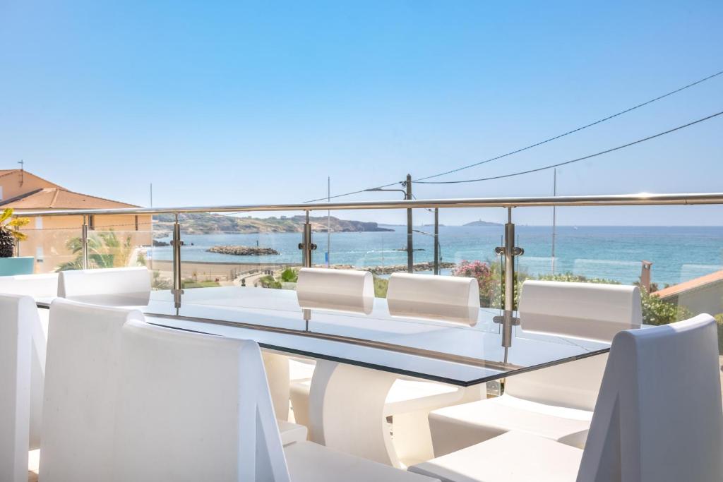 d'une table à manger et de chaises sur un balcon donnant sur l'océan. dans l'établissement Maison villa Roof top vue mer jacuzzi, à Six-Fours-les-Plages