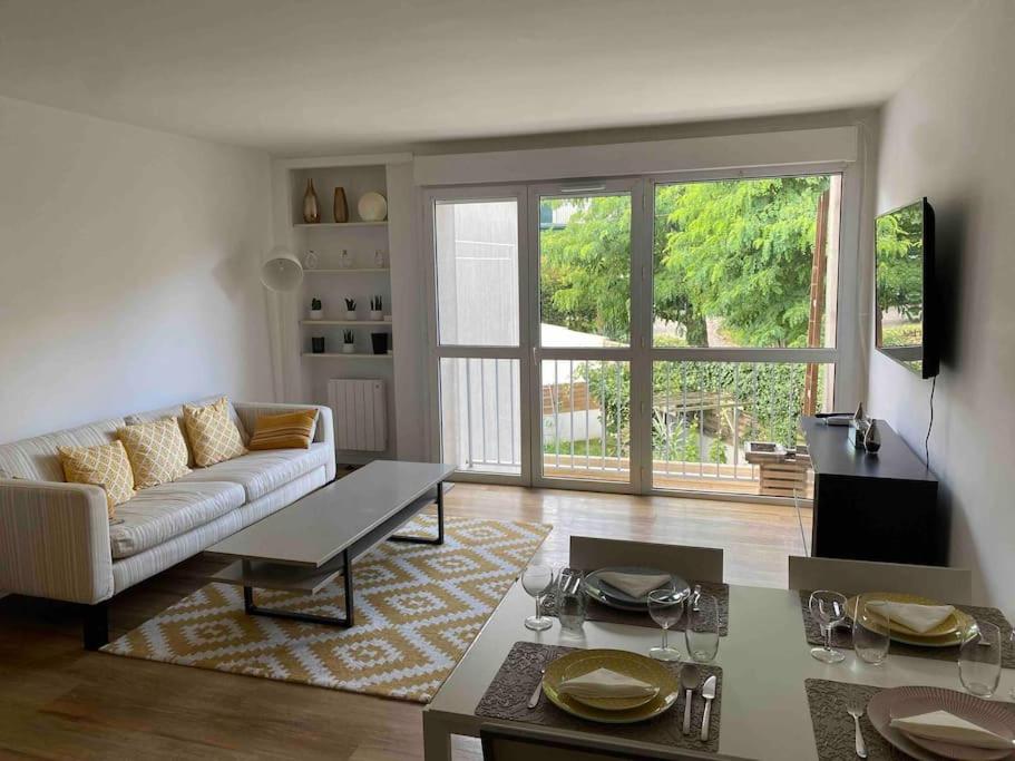 un salon avec un canapé et une table dans l'établissement Appartement cosy proche Paris, à Clamart