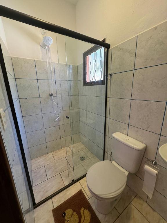 a bathroom with a toilet and a shower at Pousada Shangri-lá in Cunha