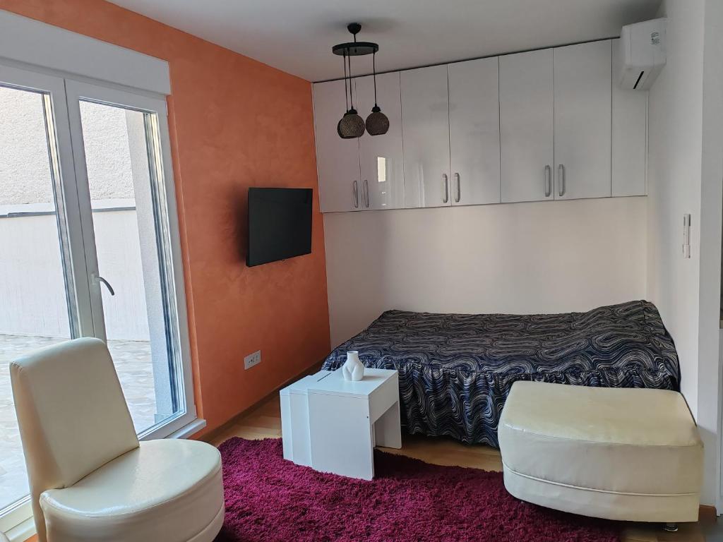 a bedroom with a bed and a chair and a window at Apartment Stevanovic Belgrade in Vračar (historical)
