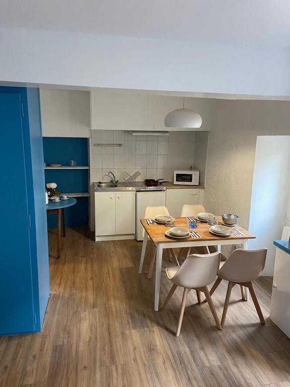 une cuisine avec une table et des chaises dans une pièce dans l'établissement Saint Père en Vézelay, à Saint-Père