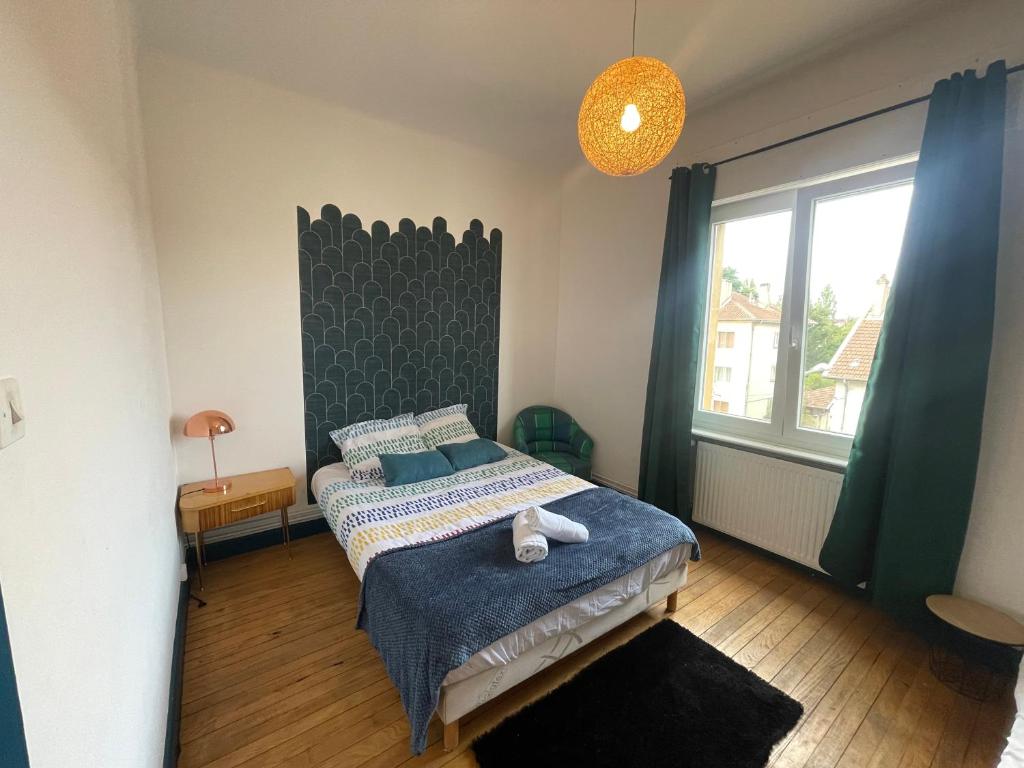 une chambre avec un lit et une grande fenêtre dans l'établissement L'Avenue 6 Lits Wifi Parking Un Séjour à Part, à Metz