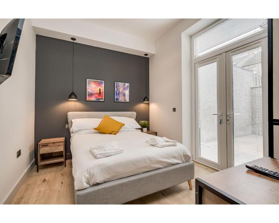 a bedroom with a bed with a yellow pillow on it at Bliss Stay Belfast University Street in Belfast