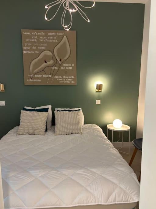 - une chambre avec un lit blanc et une affiche murale dans l'établissement Location appartements 2 pièces, aux Pennes-Mirabeau