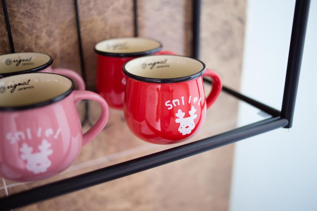 three red coffee mugs sitting on a shelf at Wei Sen House in Hualien City