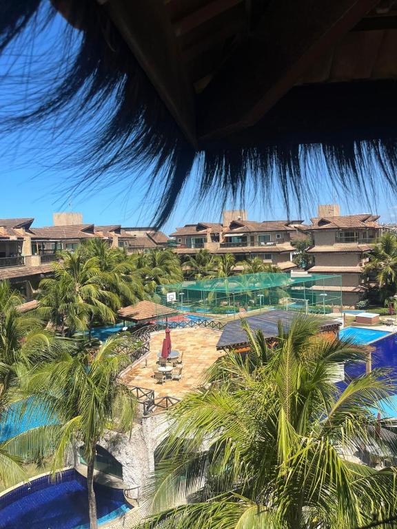 a view of a resort with palm trees and a pool at Cobertura Parque das Ilhas in Mangabeira