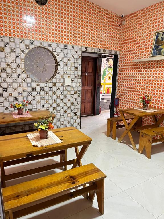a restaurant with benches and tables in a room at Paraíso Olindense in Olinda