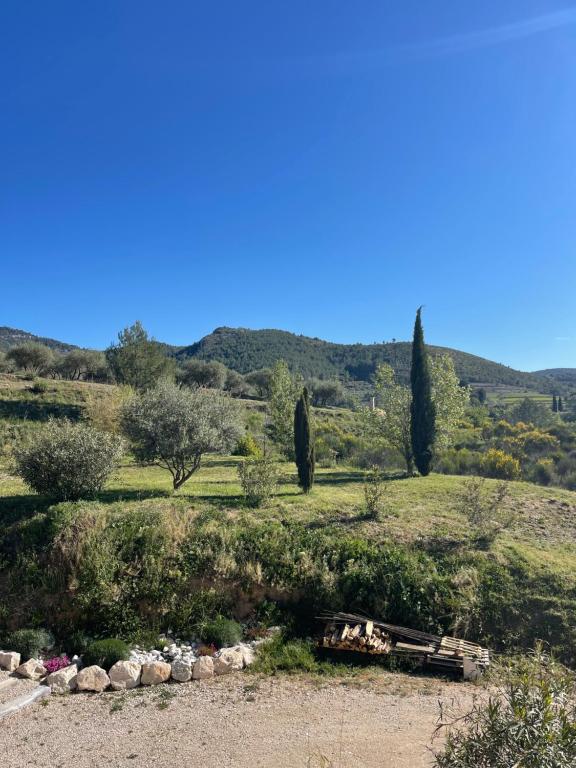 une vue sur un champ avec un banc et des arbres dans l'établissement La villa ACÉA, à Saint-Zacharie