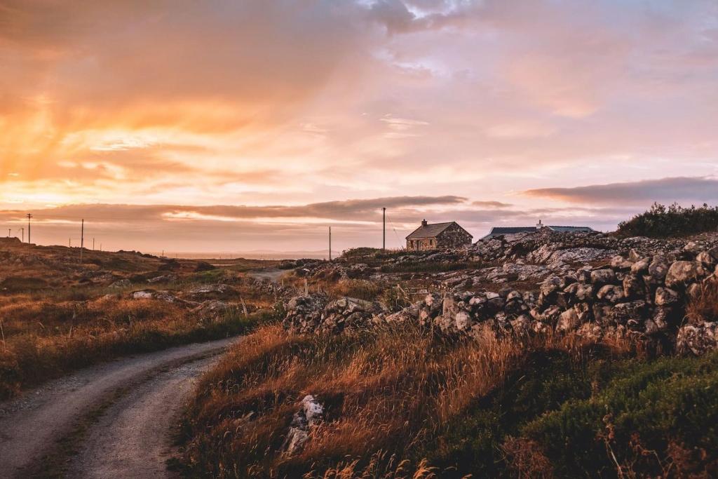a dirt road leading to a house on a hill at Paddy Carrolls Cottage in Ballyconneely
