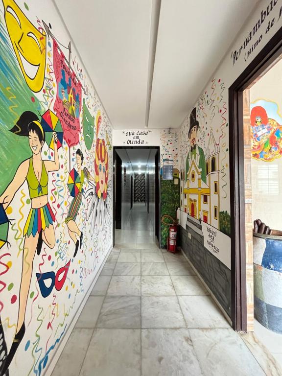 a hallway with a wall mural offamousfamousfamous people at Paraíso Olindense in Olinda