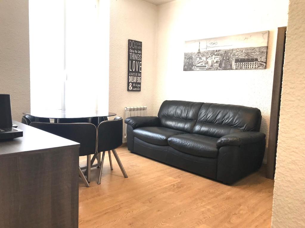 un salon avec un canapé en cuir noir et une table dans l'établissement LE CENTRE - Hypercentre - Face Parcs & Opéra - Proche Thermes, à Vichy