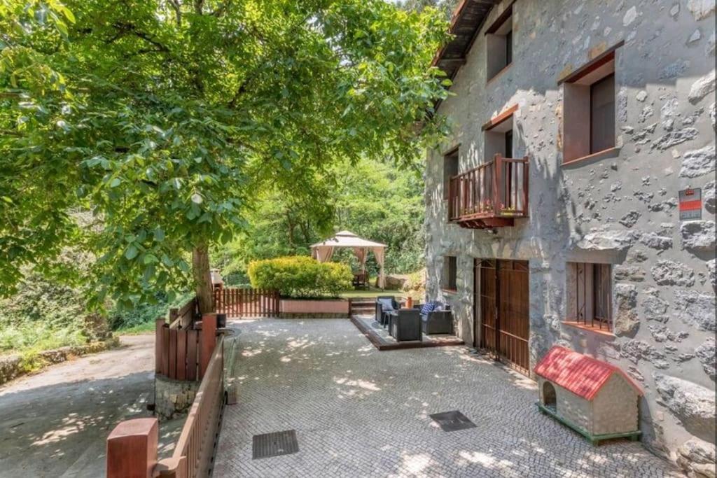 a stone building with a porch and a gazebo at Casa de piedras entre arboles, pura naturaleza in Castro-Urdiales
