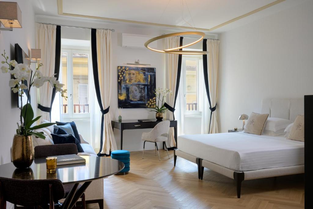 a bedroom with a bed and a living room at Tornabuoni Suites Collection Residenza D'Epoca in Florence