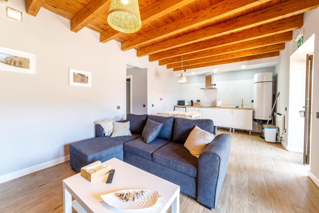 a living room with a blue couch and a table at Hotel Rural SOL in Piedrahita de Castro