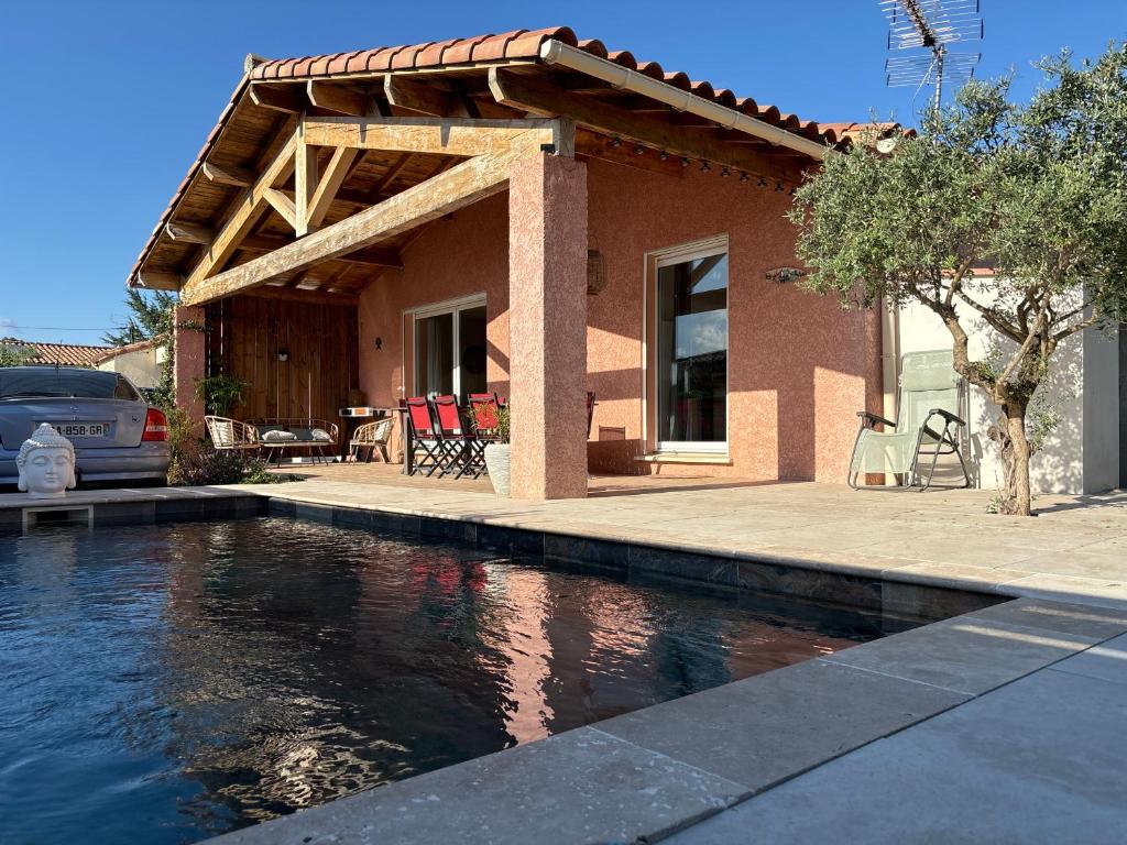 una casa con piscina di fronte a una casa di Maison 3 chambres de Sandrine et Julien a Saint-Privat-des-Vieux