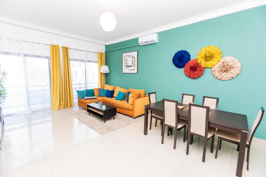 ein Wohnzimmer mit Tisch und Couch in der Unterkunft Charmant appartement 2ch près de la plage in Pointe-Noire