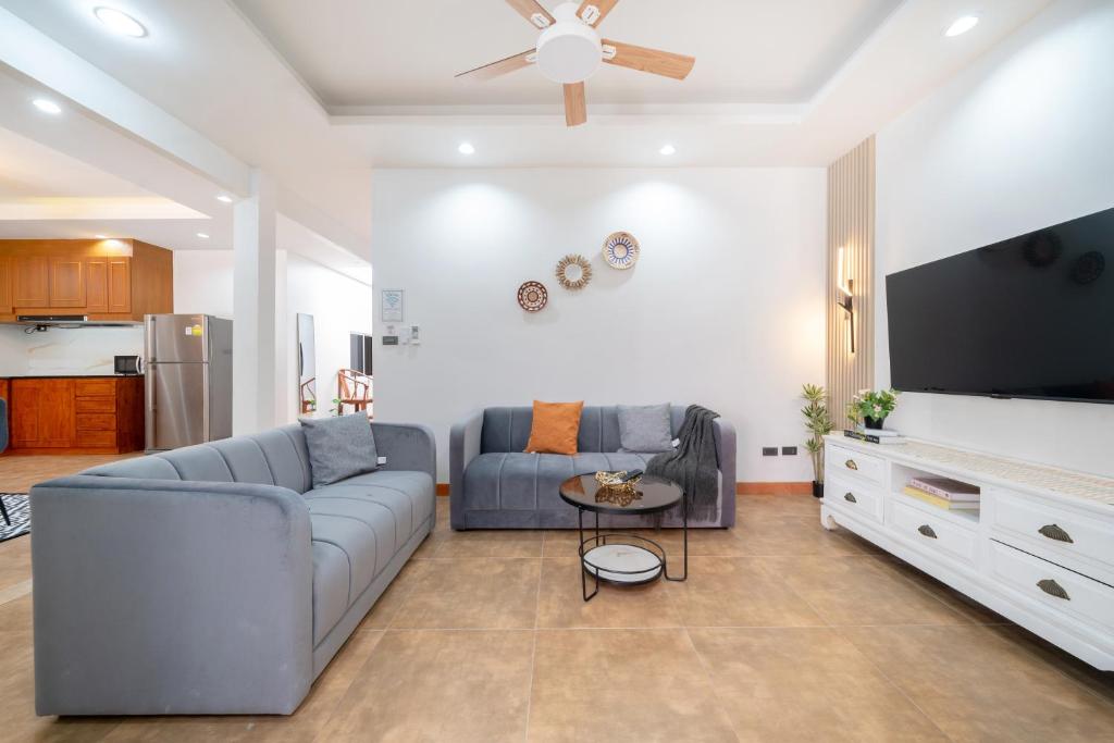 a living room with a couch and a flat screen tv at Private patong home 4BR Jazzuci and 3 BR minimal, pick the house before book in Patong Beach