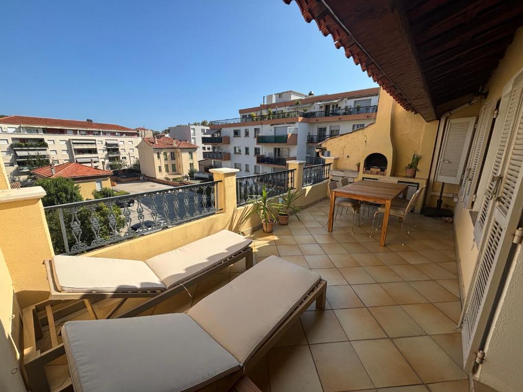 un balcon avec des chaises et une table sur un immeuble dans l'établissement Superbe duplex tout équipé, climatisation, terrasse et barbecue, à La Seyne-sur-Mer