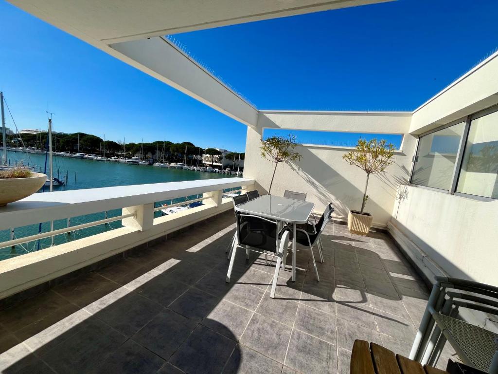 un patio avec une table et des chaises sur un balcon dans l'établissement Marina Régates, au Grau-du-Roi