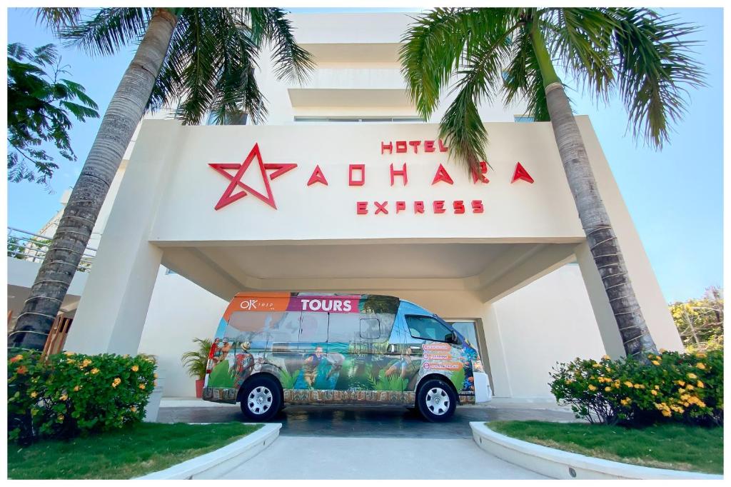 a tour bus parked in front of a building at Adhara Express in Cancún
