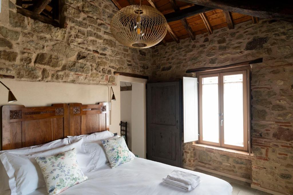a bedroom with a bed in a stone wall at Lìelà - Ospitalità di borgata in Roccavignale