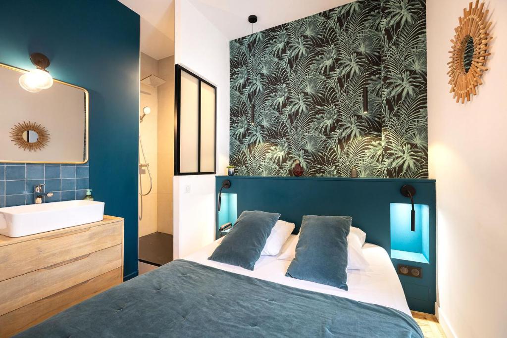 a bedroom with a large bed and a bathroom at Hotel de La Paix in La Rochelle