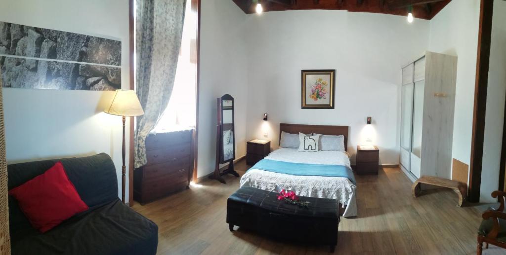 una camera da letto con un letto e un divano di Finca Las Tapias, Casa Don Juan a La Paz