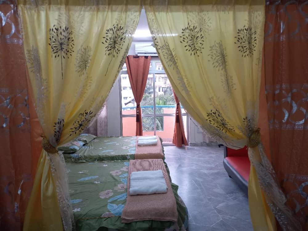 a bedroom with a bed and curtains and a window at PD BATU 9 Cocobay Resort Condominium in Kampong Tanah Merah