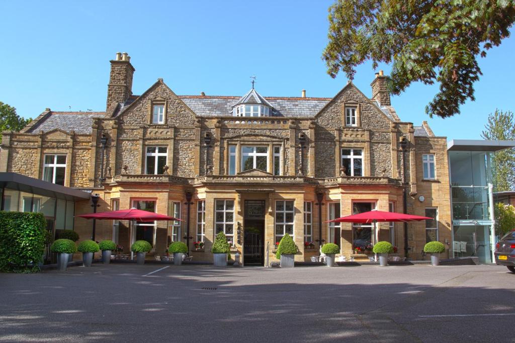 un gran edificio con sombrillas rojas delante en Lanes Hotel en Yeovil