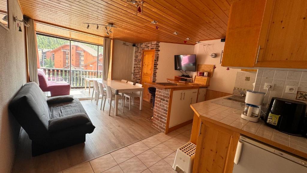 a kitchen and living room with a couch and a table at En vacances, comme à la maison in La Joue du Loup