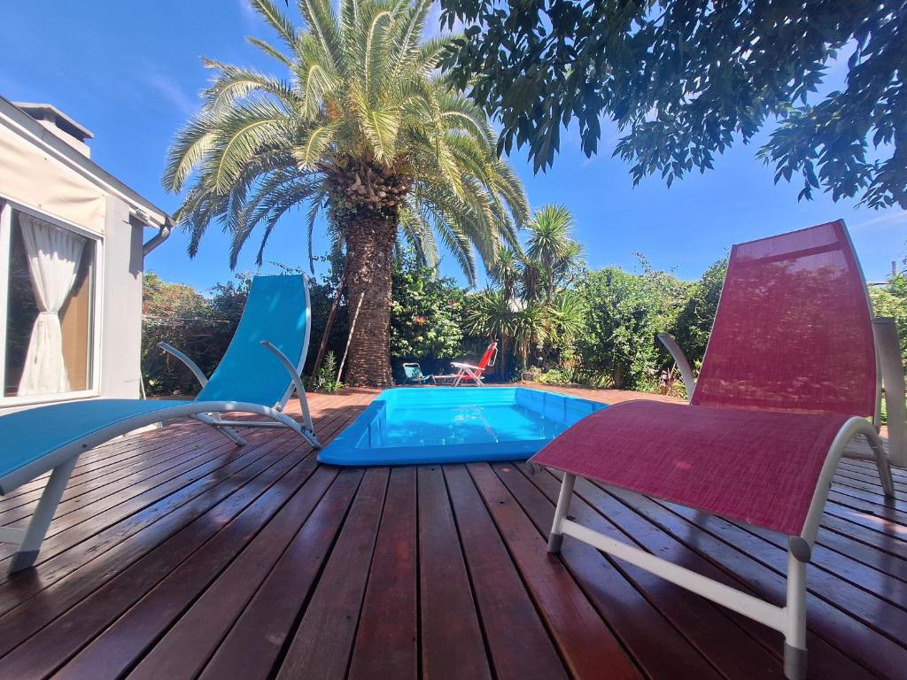 a deck with two chairs and a swimming pool at Nuestra Casa in San Pedro