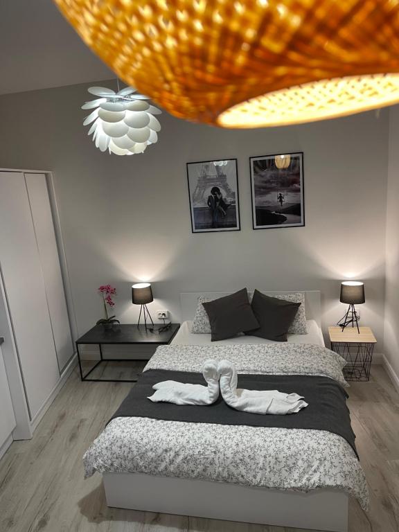 a bedroom with a bed with a white ribbon on it at Gabriela Studio Central by Gabriela Apartamente in Satu Mare