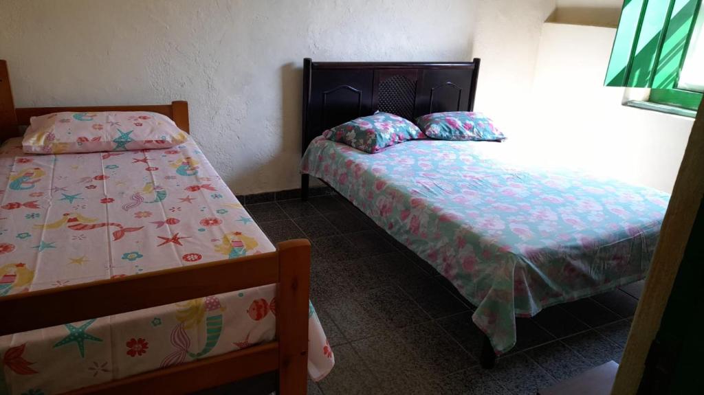 帕拉蒂Casa Completa Centro Histórico Paraty RJ的一间房间里有两张床的卧室