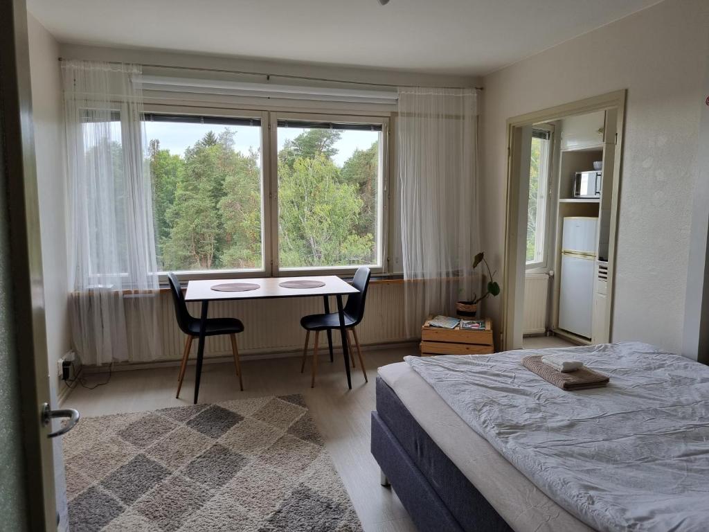 a bedroom with a bed and a desk and a window at 6. kerroksen yksiö lähellä matkakeskusta. in Lappeenranta