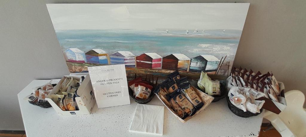 een toonbank met een schilderij van de oceaan en enkele dozen bij Hotel Delfino in Milano Marittima