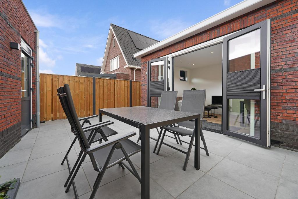 a dining table and chairs on a patio at Vakantiehuis Nieuwdorp in Nieuwdorp
