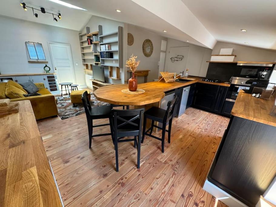 Il dispose d'une cuisine et d'un salon avec une table et des chaises en bois. dans l'établissement Appartement hyper-centre Jaude-Blatin, à Clermont-Ferrand