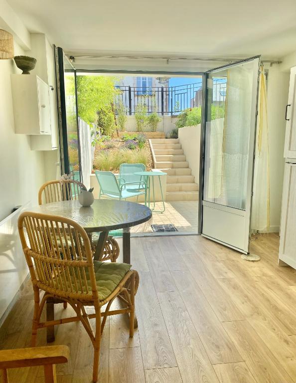 Cette chambre comprend une table, des chaises et une terrasse. dans l'établissement Appartement avec Terrasse proche du Centre-ville, à La Rochelle
