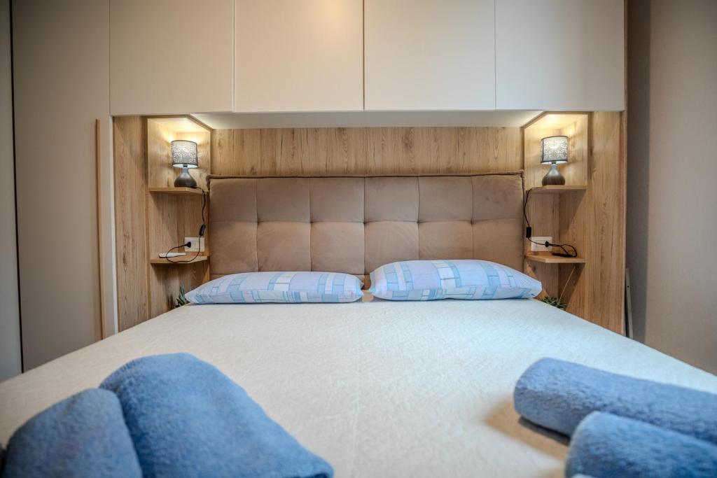 Un dormitorio con una cama grande con almohadas azules. en Perseo case vacanze Mameli Apartment, en Olbia