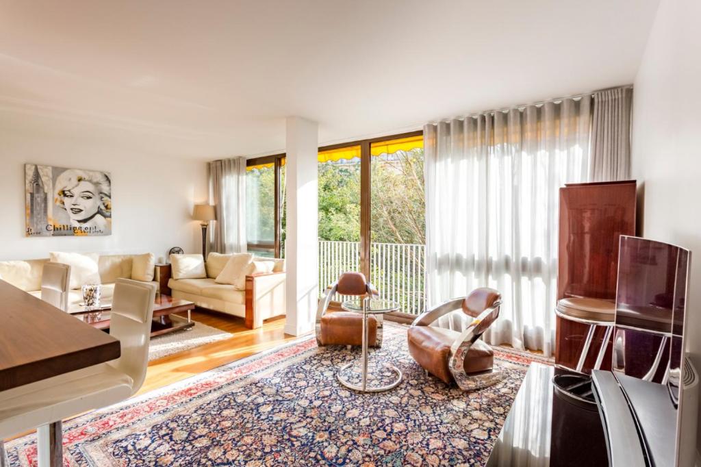 un salon avec un canapé et une table dans l'établissement Calme dans la verdure Paris 16e, à Paris