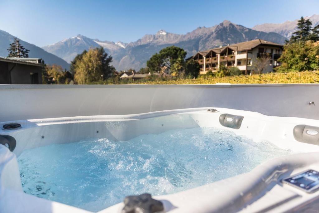 a jacuzzi tub with a view of the mountains at Chalet Merangardenvilla in Merano