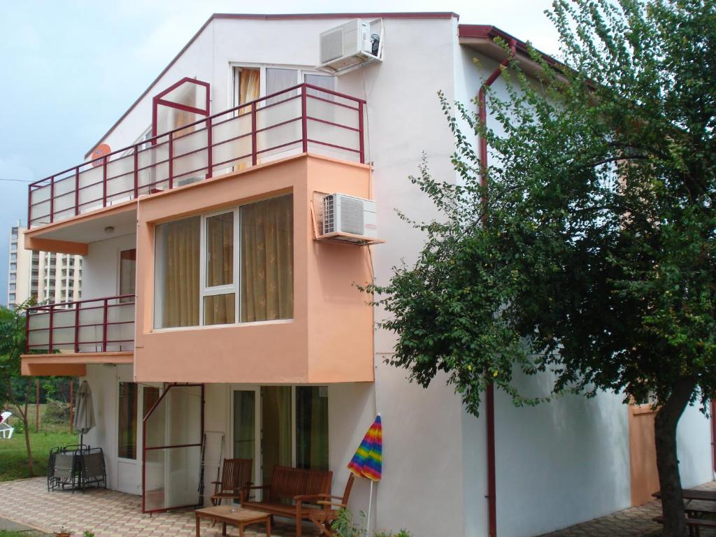 a white and pink building with a tree in front of it at Vila Bucura 19 A in Venus