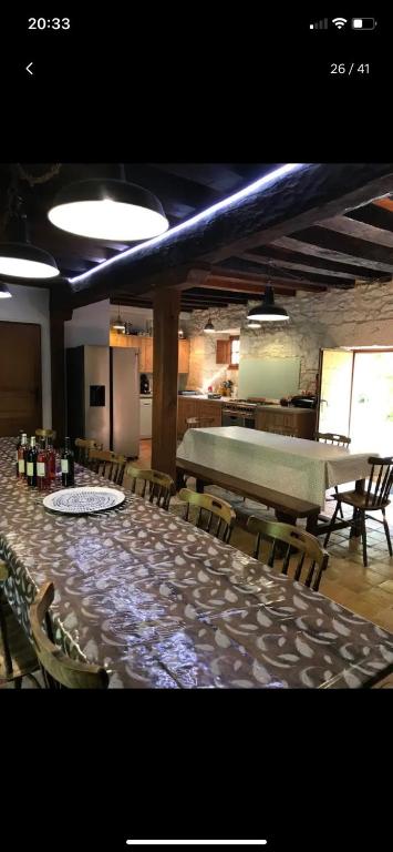 une grande salle à manger avec une longue table et des chaises dans l'établissement Moulin du grand auque, à Lalandusse